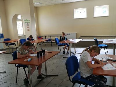 Zdjęcie przedstawia wychowanków Placówki Wsparcia Dziennego w Pękaninie, wykonujących prace plastyczne.