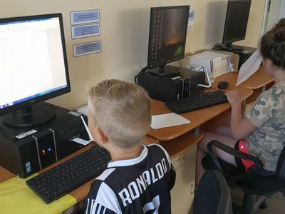 Zdjęcie przedstawia wychowanków Placówki Wsparcia Dziennego w Pękaninie przy stanowiskach komputerowych w świetlicy. 