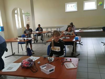 Zdjęcie przedstawia wychowanków Placówki Wsparcia Dziennego w Pękaninie, którzy konstruują roboty. 