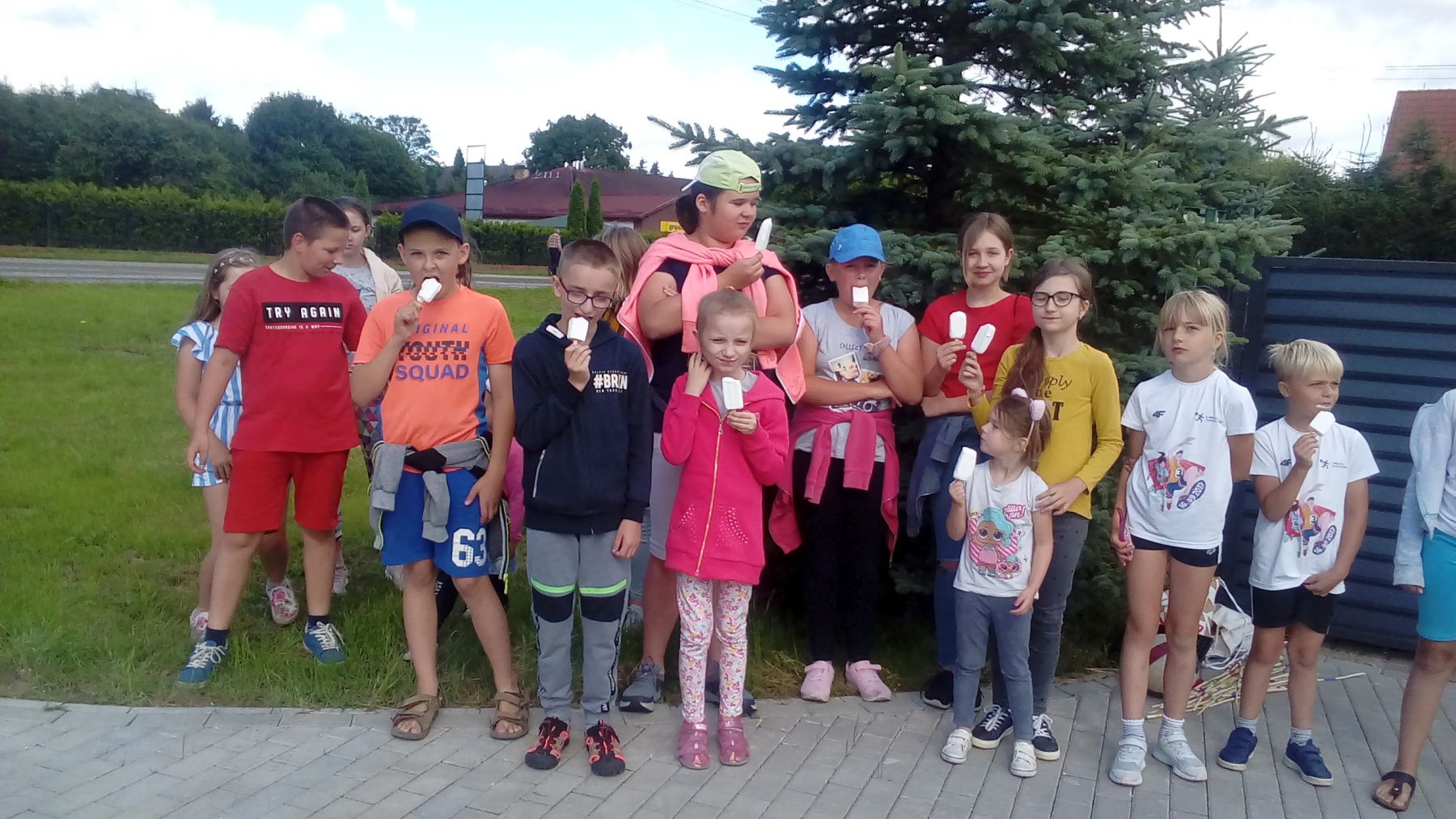 Zdjęcie przedstawia grupę wychowanków Placówki Wsparcia Dziennego w Ostrowcu pozujących przed świetlicą.