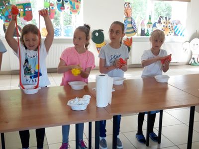 Zdjęcie przedstawia wychowankę Placówki Wsparcia Dziennego w Kosierzewie z przygotowanymi przez nich masami slime.