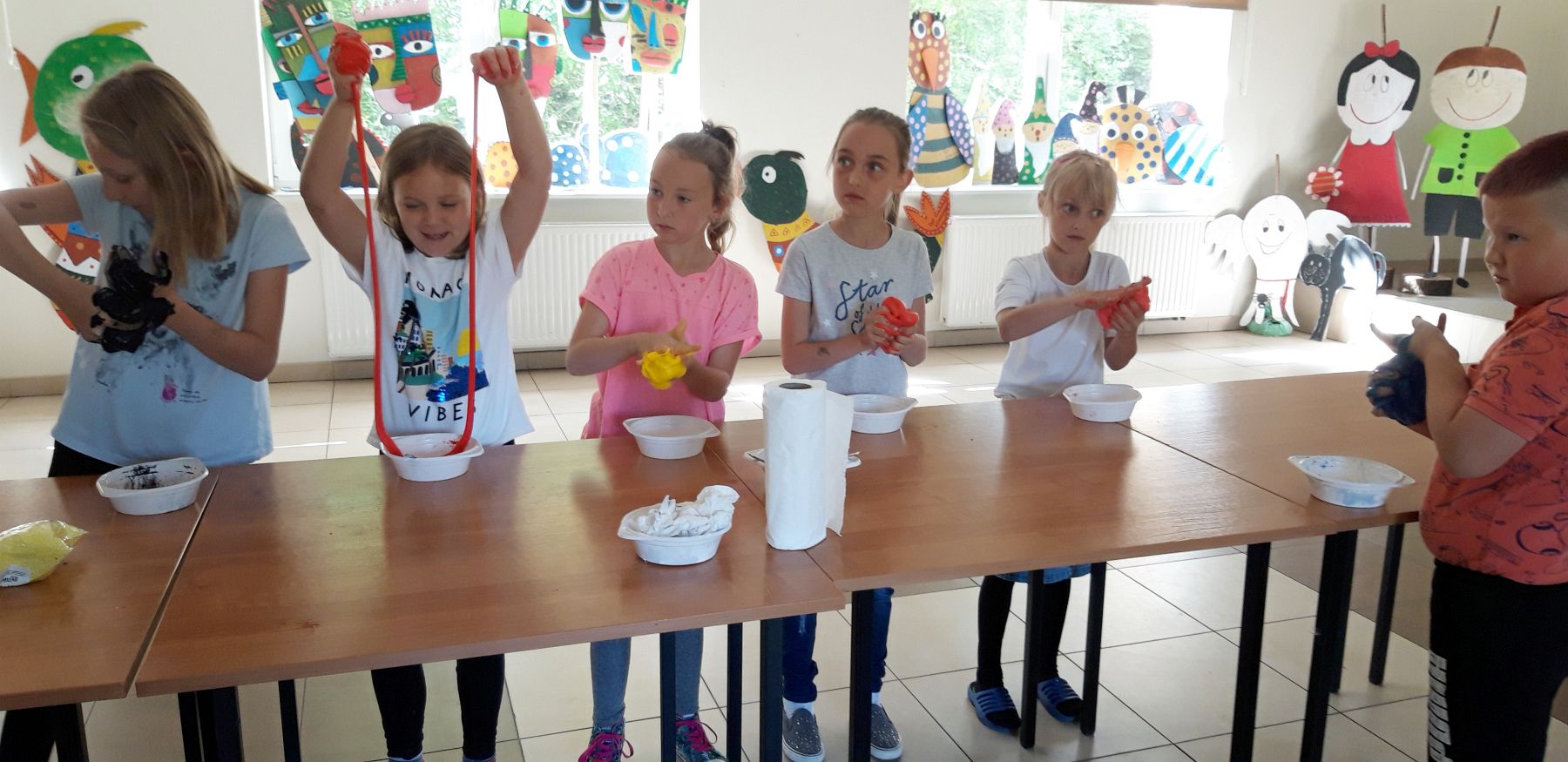 Zdjęcie przedstawia wychowankę Placówki Wsparcia Dziennego w Kosierzewie z przygotowanymi przez nich masami slime.