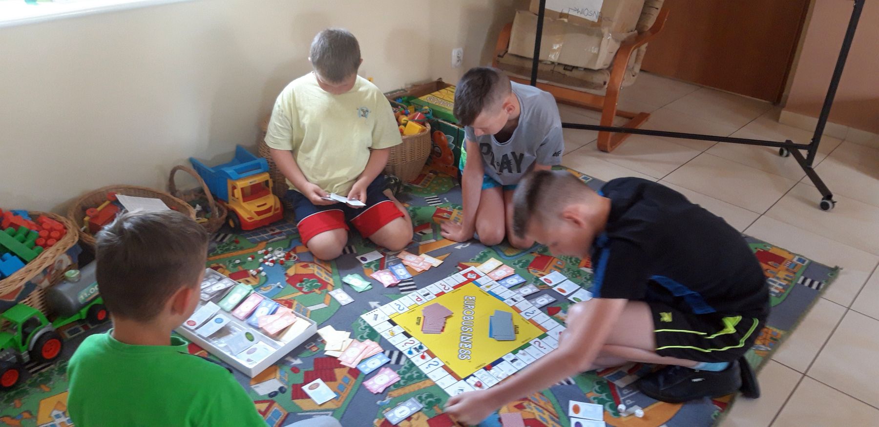 Zdjęcie przedstawia wychowanków Placówki Wsparcia Dziennego w Kosierzewie podczas gry w gry planszowe.