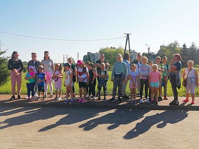 Zdjęcie przedstawia grupę wychowanków Placówki Wsparcia Dziennego z Kusic wraz z opiekunami przed parkiem rozrywki Pomerania.