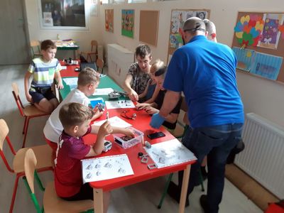 Zdjęcie przedstawia wychowanków Placówki Wsparcia Dziennego w Niemicy wraz z nauczycielem informatyki podczas zajęć z robotyki. 