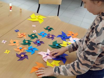 Zdjęcie przedstawia wychowanków Placówki Wsparcia Dziennego z Gorzycy z kolorowymi wiatrakami z papieru. 