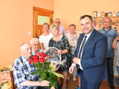 Zdjęcie przedstawia Jubilata Stanisława Filipiaka z Pękanina z rodzinką i wójta Radosława Nowakowskiego, pozujących do zdjęcia. 