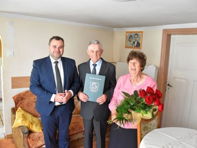  Zdjęcie przedstawia wójta Radosława Nowakowskiego oraz Jubilata Stanisława Struzik z Niemicy z listem gratulacyjnym i jego żonę Genowefę z bukietem róż. 