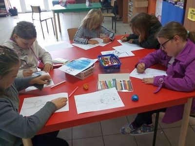 Zdjęcie przedstawia dzieci malujące kredkami z PWD z Lasek.