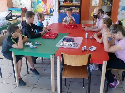 Zdjęcie przedstawia wychowanków PWD Laski podczas zajęć z robotyki wraz z nauczycielem.