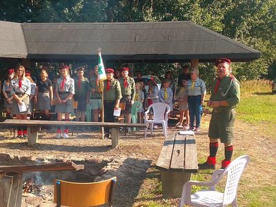 Zdjęcie przedstawia grupę harcerzy biorących udział w spotkaniu integracyjnym przy wiatce na boisku w Ostrowcu. 