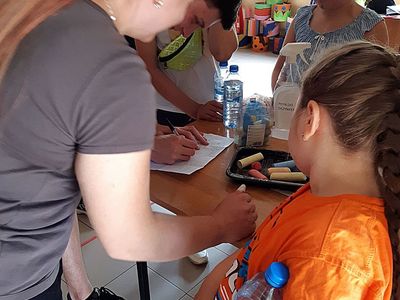 Zdjęcie przedstawia wychowanków Placówki Wsparcia Dziennego z Paprot podczas zapoznania z zasadami gry.