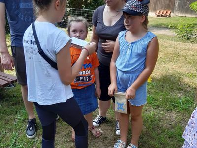 Zdjęcie przedstawia wychowanków Placówki Wsparcia Dziennego z Paprot podczas losowania nagród niespodzianek za udział w zabawie.