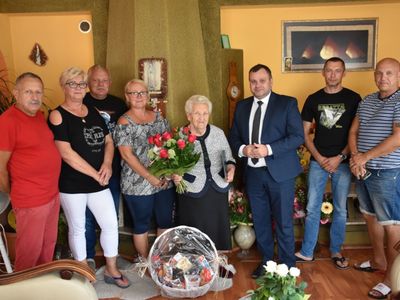 Zdjęcie grupowe przedstawia Jubilatkę, Panią Marię Musielaniec w obecności wójta Radosława Nowakowskiego oraz jej synów i rodziny.
