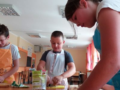 Zdjęcie przedstawia wychowanków PWD Laski podczas przygotowywania na zajęciach kulinarnych  owsianych ciasteczek.