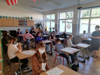 Zdjęcie przedstawia uczniów ze szkoły w Lejkowie z nauczycielem, którzy znajdują się w klasie.