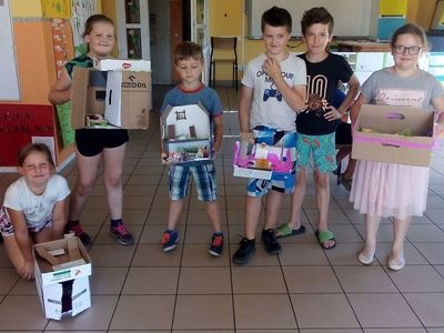Zdjęcie przedstawia grupkę dzieci z PWD Laski z wykonanymi własnoręcznie domkami.
