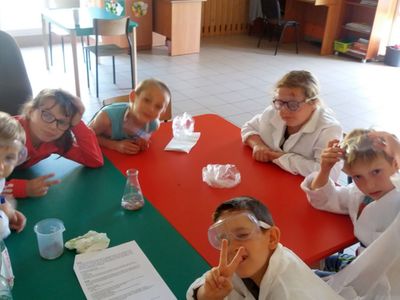 Zdjęcie przedstawia grupkę dzieci z PWD w Laskach podczas zajęć fizyczno- chemicznych z elementami matematyki.