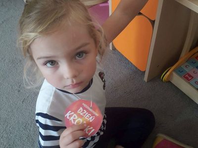 Zdjęcie przedstawia dziewczynkę z przedszkola w Niemicy pozującą z odznaką "Międzynarodowy Dzień Kropki".