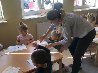 Zdjęcie przedstawia przedszkolaki z przedszkola w Niemicy wraz z wychowawczynią podczas prac plastycznych.
