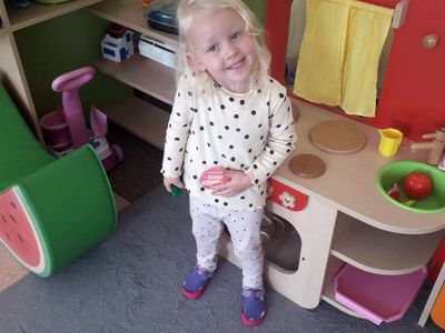 Zdjęcie przedstawia dziewczynkę z przedszkola w Niemicy pozującą z odznaką "Międzynarodowy Dzień Kropki". 