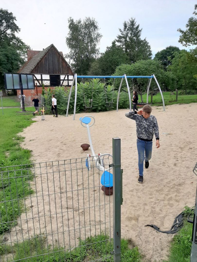 Zdjęcie przedstawia dzieci z PWD Przystawy na placu zabaw podczas pikniku rodzinnego.