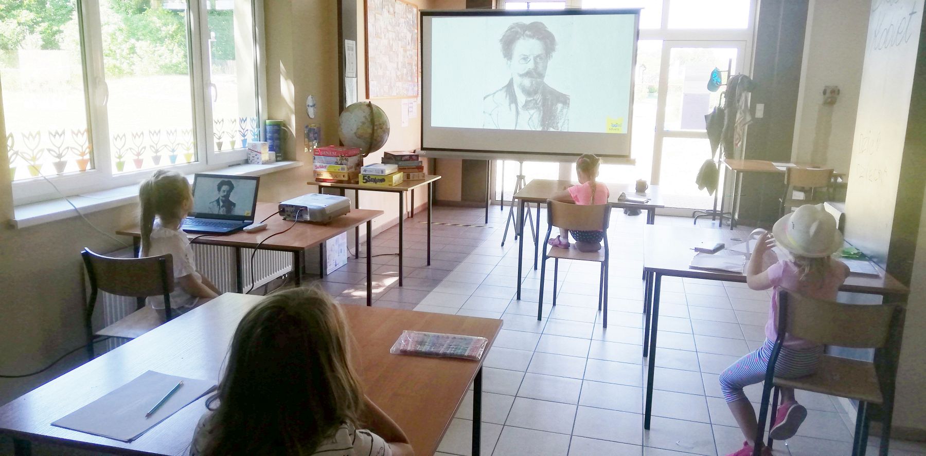 Zdjęcie przedstawia dzieci z Pwd w Sulechowie oglądające prezentację multimedialną podczas zajęć dziennikarskich.