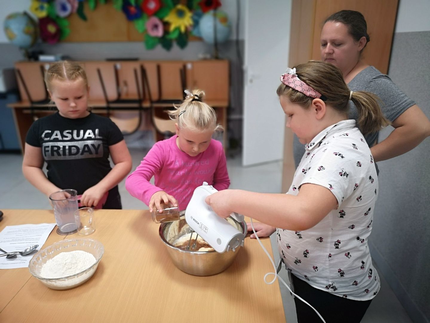 Zdjęcie przedstawia wychowanków PWD Kusice podczas przygotowywania babeczek. 