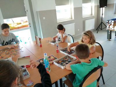 Zdjęcie przedstawia dzieci z Placówki Wsparcia Dziennego w Kusicach podczas konkursu z puzzlami.