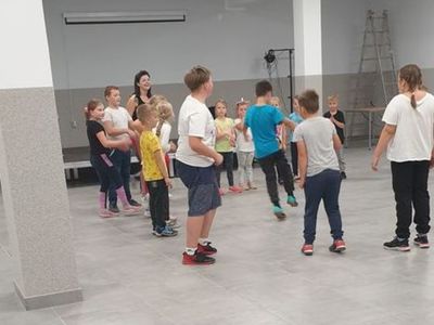 Zdjęcie przedstawia dzieci uczestniczące w zajęciach breakdance w Świetlicy Kultury w Malechowie wraz z instruktorką.