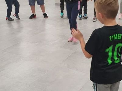 Zdjęcie przedstawia dzieci uczestniczące w zajęciach breakdance w Świetlicy Kultury w Malechowie. 