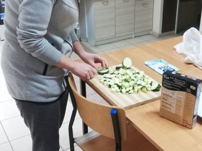 Zdjęcie przedstawia mamę jednego z wychowanków PWD w Sulechowie podczas krojenia warzyw.