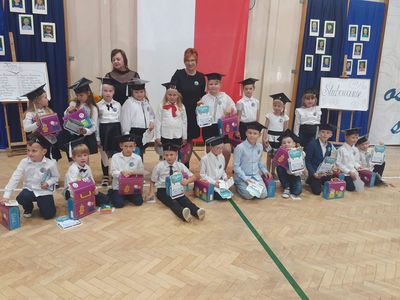 Uczniowie klasy pierwszej na wspólnym zdjęciu z panią dyrektor i wychowawcą.