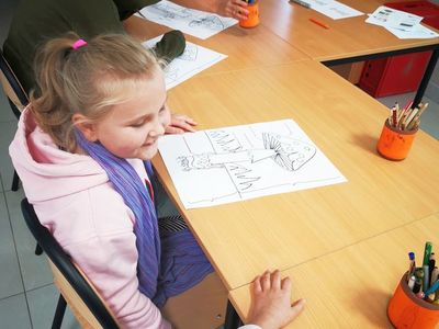 Dziecko z PWD Kusice podczas uzupełniania karty pracy.