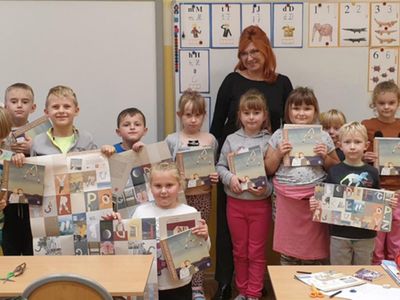 Uczniowie klasy I ze Szkoły Podstawowej w Niemicy razem z wychowawcą demonstrują swoje prezenty w postaci książek i kreatywnego alfabetu.