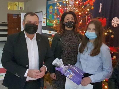 Wójt Radosław Nowakowski, Joanna Sawicka, Amelia Durkalec pozują do zdjęcia w świątecznej aurze. 