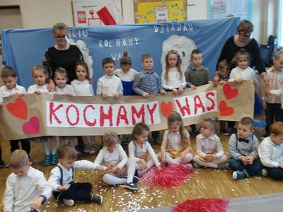 Przedszkolaki z Ostrowca z transparentem Kochamy Wam wraz z wychowawczyniami.