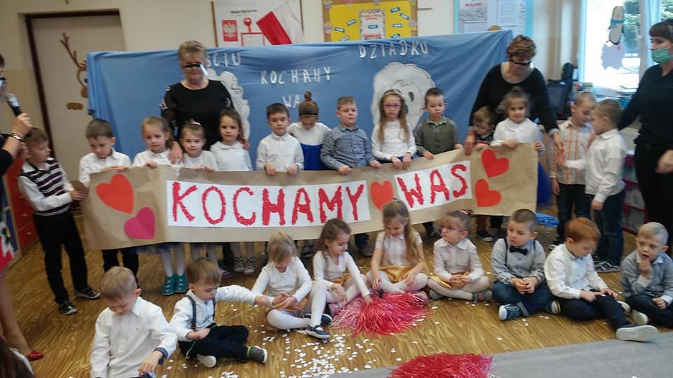 Przedszkolaki z Ostrowca z transparentem Kochamy Wam wraz z wychowawczyniami. 