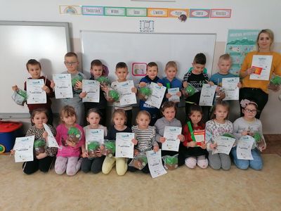 Grupa Pracowitych Jeżyków z wychowawczynią pozuje z dyplomami, które dzieci otrzymały w ramach konkursu sieci Biedronka "Szkolne przygody Gangu Fajniaków". 