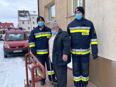 Strażacy z OSP Malechowo i senior, który został zaszczepiony przed budynkiem malechowskiego Zakładu Opieki Zdrowotnej. 