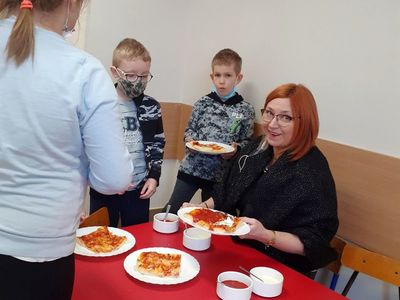 Dzieci z SP Niemica z nauczycielką podczas jedzenia pizzy. 