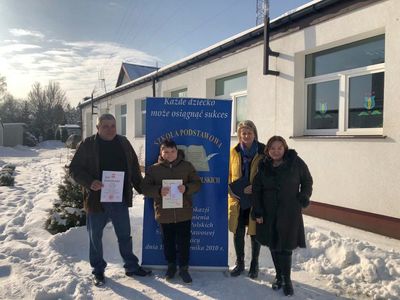 Wręczenie stypendium uczniowi z klasy VII ze Szkoły Podstawowej im. Noblistów Polskich w Niemicy. Chłopcu towarzyszy tata, wychowawczyni oraz dyrektor placówki. 