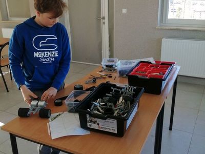 Chłopiec z Placówki Wsparcia Dziennego w Kusicach w trakcie składania robota z klocków lego.