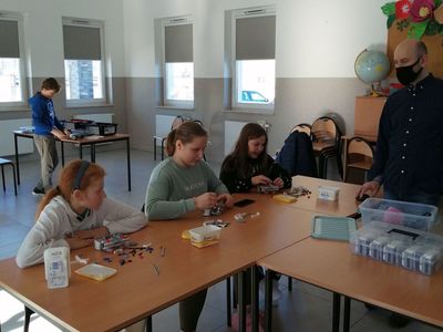  Dzieci z Placówki Wsparcia Dziennego w Kusicach wraz z prowadzącym zajęcia podczas zajęć z robotyki. 