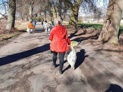 Mieszkańcy Lasek idący drogą z workami na odpady.