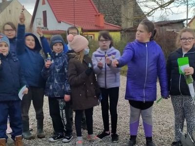 Grupa dzieci z  Placówki Wsparcia Dziennego z Lasek z lizakami  w dłoniach. 