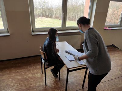 Nauczycielka z Zespołu Szkół w Ostrowcu przekazuje uczennicy arkusz egzaminacyjny. 