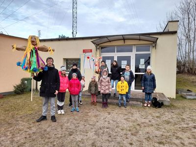 Dzieci z Placówki Wsparcia Dziennego z Sulechowa przed budynkiem świetlicy z przygotowaną kukłą oraz tradycyjnym gaikiem.