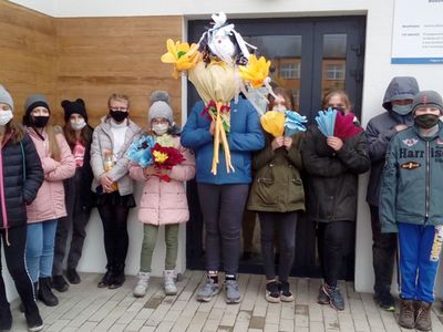 Wychowankowie Placówki Wsparcia Dziennego w Ostrowcu z przygotowaną kukłą przed budynkiem świetlicy.