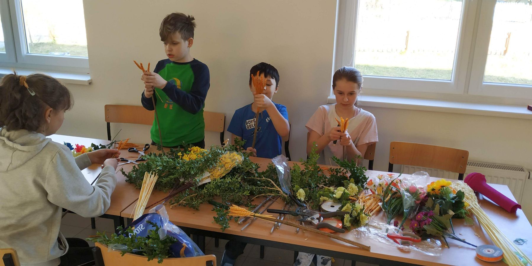 Wychowankowie Placówki Wsparcia Dziennego w Gorzycy podczas przygotowywania palm.